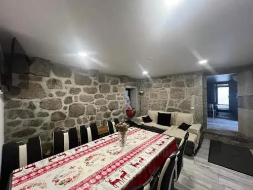 a dining room with a table and a stone wall at Charming Villa with Pool and Jacuzzi - Terras de Bouro in Terras de Bouro