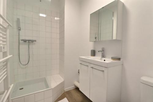 une salle de bain blanche avec un lavabo et une douche dans l'établissement Aux nuances de clairs - Studio cosy dans quartier historique cathédrale - Mon Groom, à Troyes