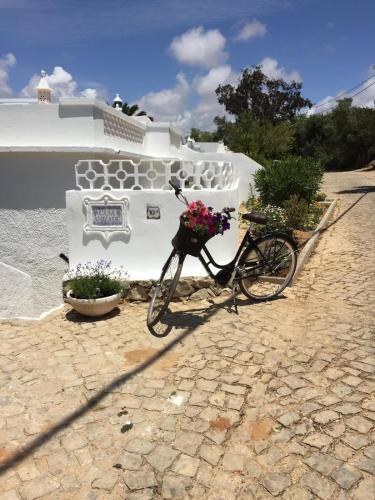 a bike parked in front of a building with flowers at Luxury 2 Bedroom Villa on Quinta da Saudade in Pêra