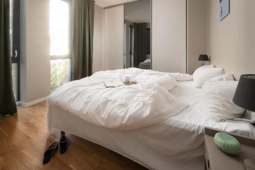 a large white bed in a room with a window at BJØRVIKA APARTMENTS, Opera Area, Oslo city center in Oslo