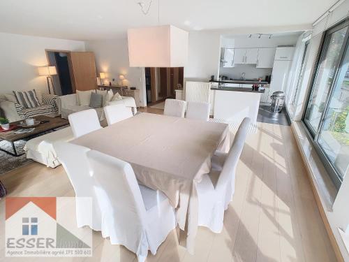 a dining room with a white table and white chairs at Appartement 120m2 plus terrasse in Brussels