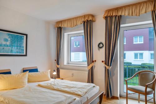 a bedroom with a bed and a chair and a window at Ferienwohnung Tannenblick 3-1 in Oberhof