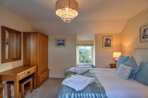 a bedroom with a bed and a desk and a window at Finest Retreats - Trennal Barn in Germoe