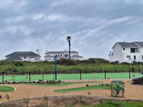 a tennis court with a tennis court at Shelley On Sea in Stompneusbaai