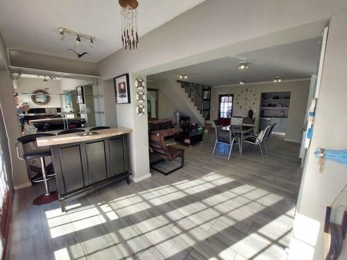 a kitchen and living room with a table and chairs at Shelley On Sea in Stompneusbaai