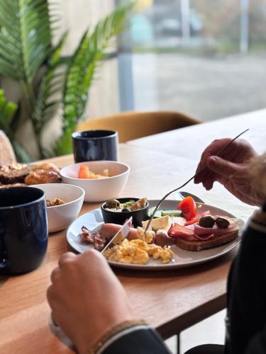 ein Teller mit Lebensmitteln auf einem Tisch mit einem Teller Lebensmittel in der Unterkunft 7Hotel&Spa in Illkirch-Graffenstaden