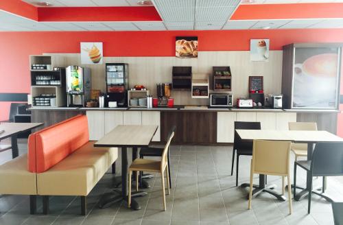 a fast food restaurant with tables and a counter at Ace Hotel Creutzwald Saint Avold in Creutzwald-la-Croix