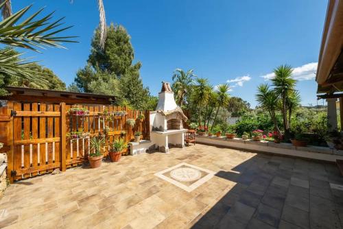 a backyard with a wooden fence and a fireplace at Al mare a Capo Comino in Capo Comino