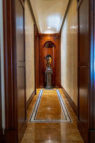 a hallway in a building with a statue on the floor at Casa Rajada Sorrento in Sorrento
