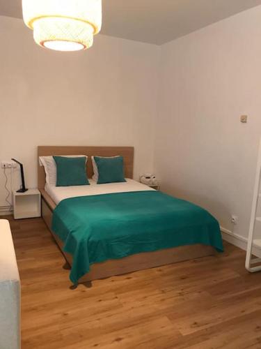 une chambre avec un lit avec une couverture verte dessus dans l'établissement Home & Home Metz Arènes, ctr congres, Muse, Pompidou, à Metz