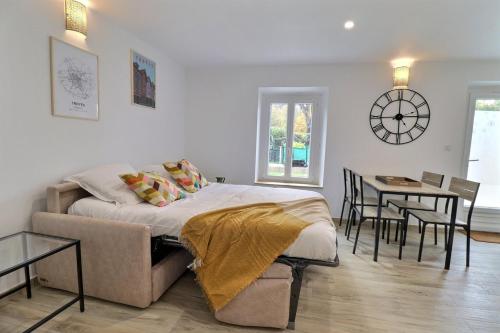 une chambre avec un lit et une table avec des chaises dans l'établissement Le Verd'oyant - Calme et Parking - Proche Centre - Mon Groom, à Troyes