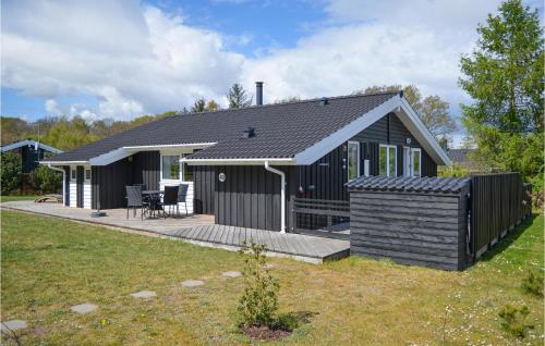 una casa negra con terraza en un patio en Nice Home In Glesborg With Sauna, en Glesborg