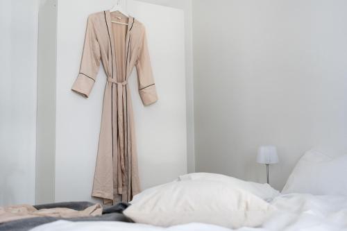 a robe hanging on a wall next to a bed at BJØRVIKA APARTMENTS, Opera Area, Oslo city center in Oslo