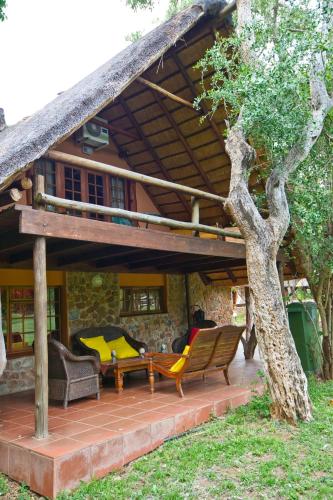 a patio with chairs and a thatched roof at Blyde River Canyon Lodge in Hoedspruit