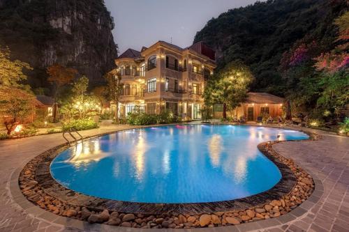 a large swimming pool in front of a house at Indochine Boutique Hotel Ninh Bình in Ninh Binh