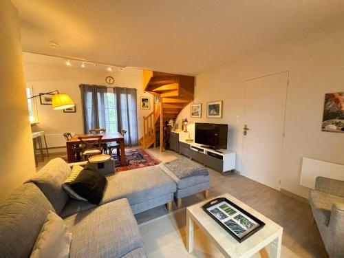 a living room with a couch and a table at Joli T3 au pied du Golf - The 19th Hole in Bellême