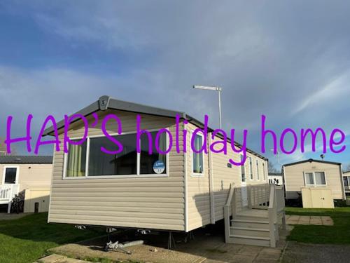 a house with a sign that says happy holidays at HAPs Holiday Home - Haven The Orchards in Brightlingsea