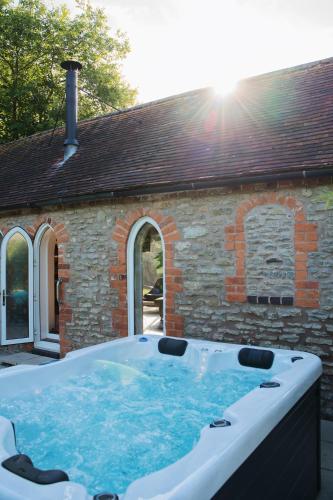 a hot tub in front of a brick building at The Hornbill at Home Farm Shropshire in Shrewsbury