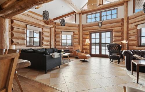 una sala de estar con paredes y muebles de madera y ventanas en Stunning Home In Nimtofte With Kitchen, en Nimtofte