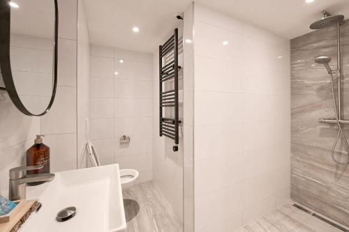 a white bathroom with a shower and a sink at Stratum's Theo's Loft - By T&S in Eindhoven