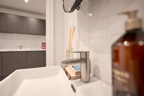 a sink with a faucet and a bottle of soap at Stratum's Theo's Loft - By T&S in Eindhoven