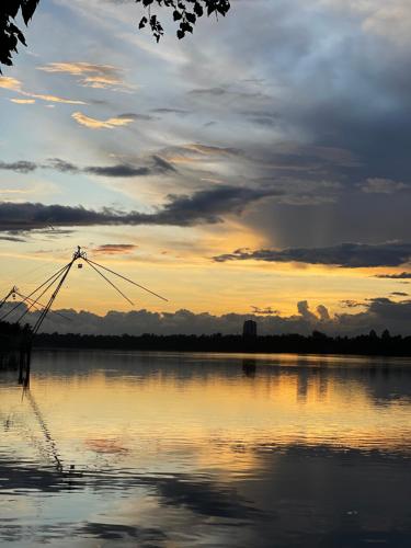 a view of a lake at sunset at AshtamudiVillas in Kollam