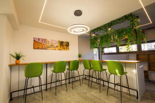 a bar with green chairs in a room at Vila Carol in Alba Iulia