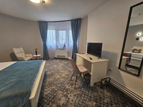 a bedroom with a bed and a desk with a computer at Vila Carol in Alba Iulia