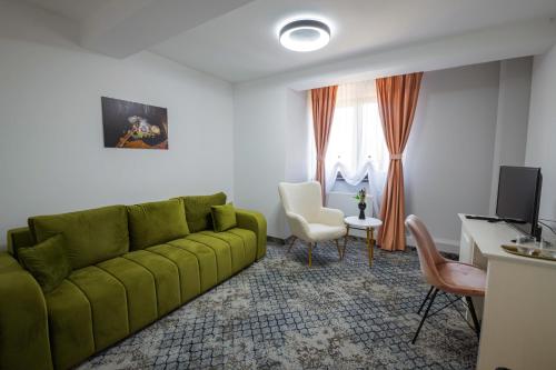a living room with a green couch and a desk at Vila Carol in Alba Iulia