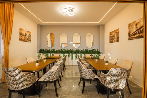 a dining room with tables and chairs and mirrors at Vila Carol in Alba Iulia