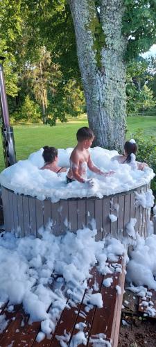 a group of children in a hot tub with snow at Sodyba Po klevu in Molėtai