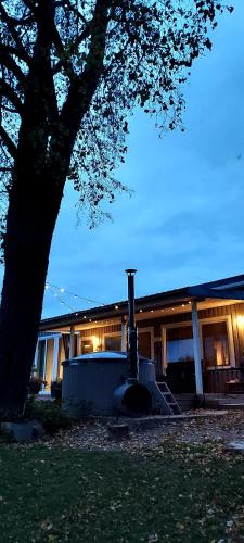 a house with a fireplace in front of it at Sodyba Po klevu in Molėtai