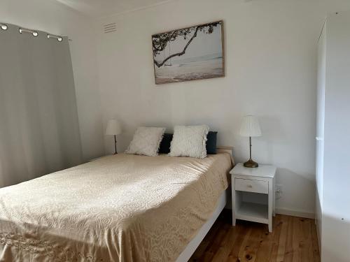 a bedroom with a bed and a picture on the wall at Rye Holiday Getaway BYO Linen and Towels 750m walk to Beach in Rye