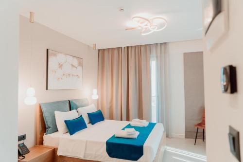a bedroom with a large bed with blue pillows at Sky Boutique Hotel in Perea