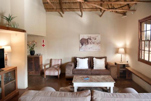 a living room with a couch and a table at Dalmore Guest Farm in Bergville