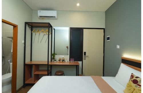 a bedroom with a bed and a bathroom with a mirror at Grand Valora Puspowarno Kostel in Kalibanteng-lor