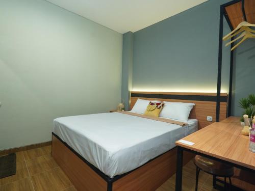 a bedroom with a bed and a wooden table at Grand Valora Puspowarno Kostel in Kalibanteng-lor
