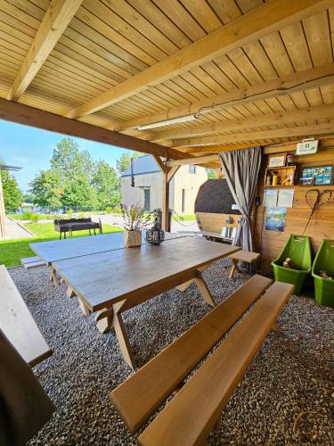 a patio with a wooden table and benches at Hytte Na Wyspie -,,Roztoczańskie Morze'' in Kulików