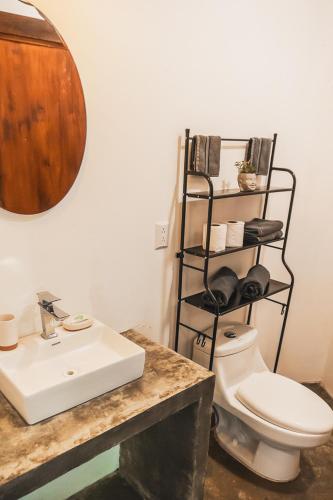 a bathroom with a white toilet and a sink at Peaceful Jungle Villa Kona - Pool & Parking for 2 persons in Puerto Viejo