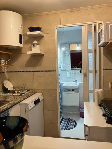 a small kitchen with a sink and a bathroom at Habitaciones Yanet in La Granada