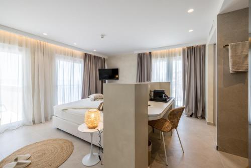 a hotel room with a bed and a desk and a table at Hotel Aria in Podstrana