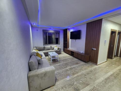 een woonkamer met een bank en een flatscreen-tv bij Évasion élégante à Marrakech in Marrakesh