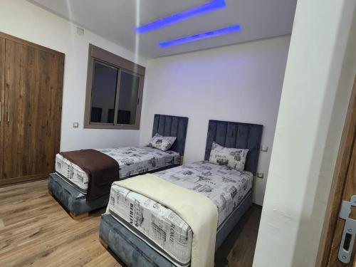 een slaapkamer met 2 bedden en een blauw plafond bij Évasion élégante à Marrakech in Marrakesh