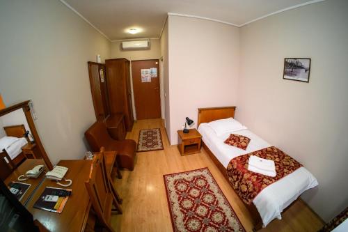a small room with a bed and a desk with a desk at Hotel Transilvania in Cluj-Napoca