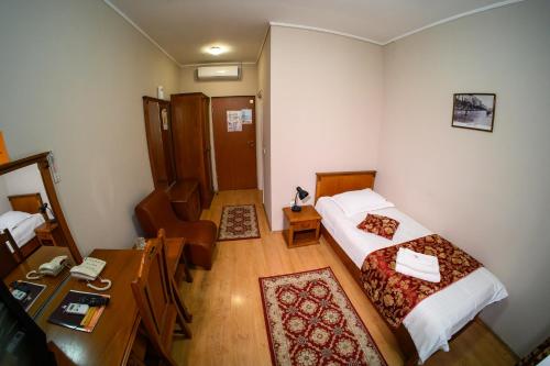 a small room with a bed and a desk with a desk at Hotel Transilvania in Cluj-Napoca