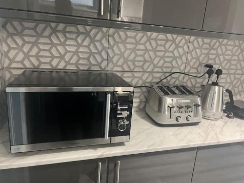 d'un four micro-ondes et d'un grille-pain sur un comptoir de cuisine. dans l'établissement 4 Bedroom semi detached House London, à Edgware