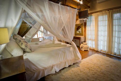 a bedroom with a white bed with a canopy at Blyde River Canyon Lodge in Hoedspruit