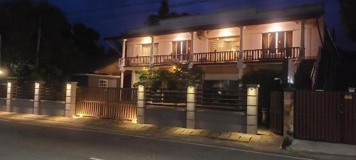 a house with a fence in front of it at night at GG Lodge Mirissa in Mirissa