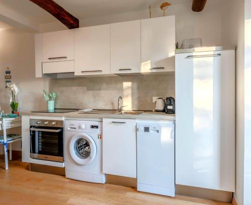 a kitchen with white cabinets and a washer and dryer at Your Sea Escape in Riva Trigoso