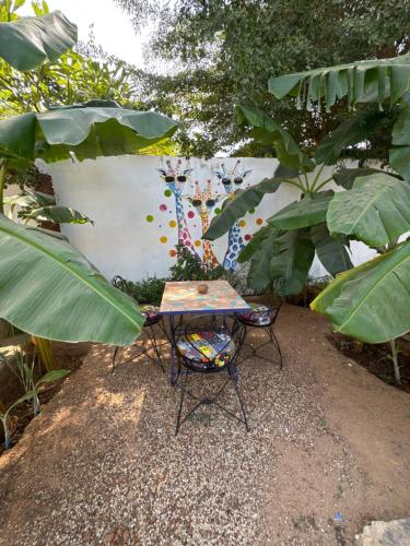 a table and two chairs in front of a wall at Kayzen house in Ngaparou